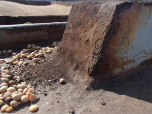 Hatch cover maintenance, image shows hatch coaming not swept, cargo debris and rust still evident. Centreline joint closing wedge showing severe wear.